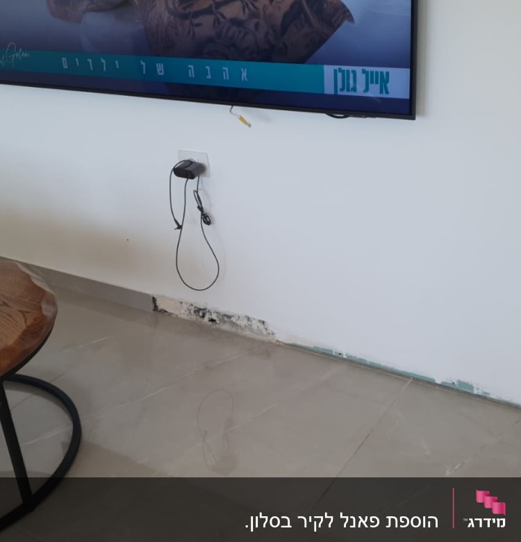 שואב אבק על שולחן עץ ליד קיר עם טלוויזיה